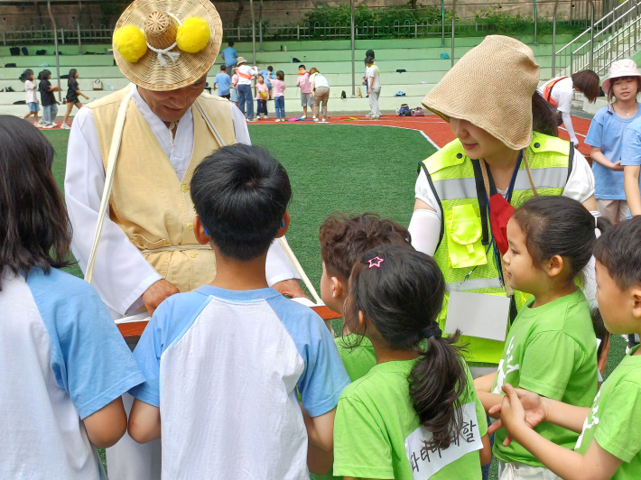 엿장수로 변장한 교장선생이 엿 파는 전경  