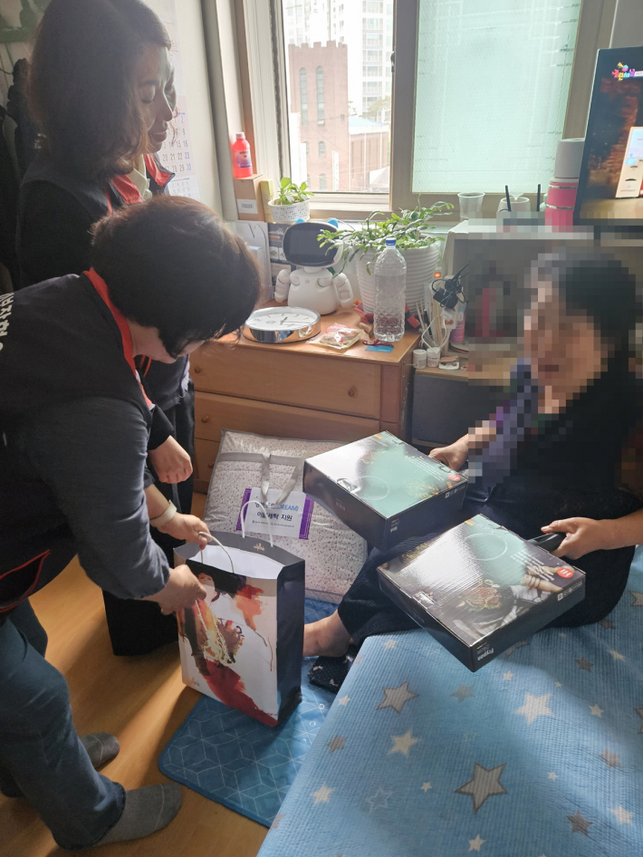 노후된 프라이팬을 새로운 프라이팬으로 바꾸고 안부를 확인하고 있는 지역사회보장협의체 위원