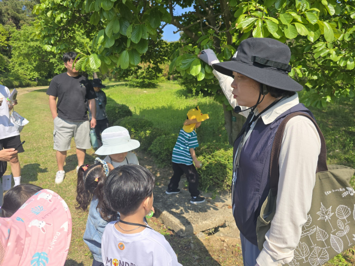 이경옥 숲 해설사가 아이들에게 나뭇잎과 곤충의 흔적에 대해 설명하고 있다.