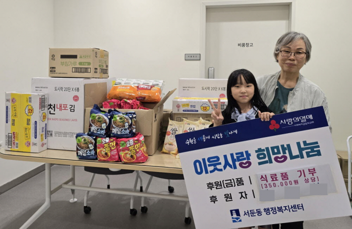 아동이 할머니와 함께 후원물품을 전달하고 있다.