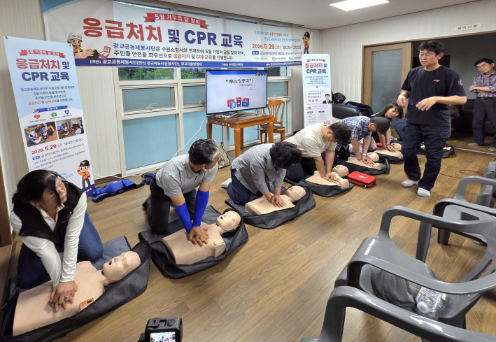 교육에 참여한 광교 지역 주민들과 봉사자들이 진지한 표정으로 심폐소생술 가슴 압박 실습에 임하고 있다.