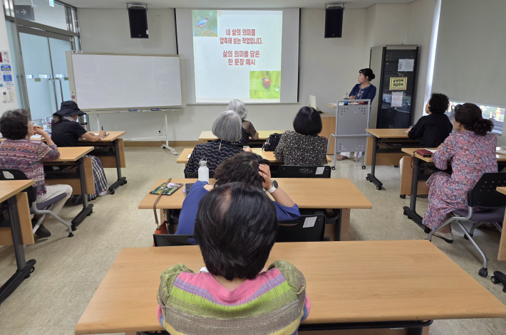 화면에 띄워진 '내 삶의 의미를 압축해 보는 작업' 안내를 보며, 수강 어르신들이 지나온 인행 여정을 깊이 있게 성찰하고 있다.