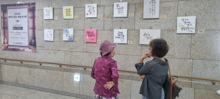 작품에 대해 이야기를 나누는 복지관에서의 관람객
