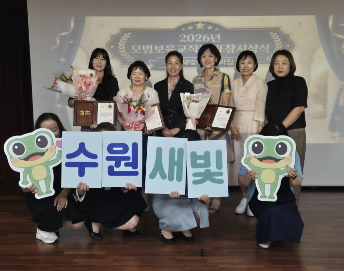 김은주 수원시 여성가족국장(뒷줄 왼쪽 3번째)과 수원새빛형어린이집 발전 유공자 표창을 받은 보육교직원들이 기념사진을 촬영하고 있다.     