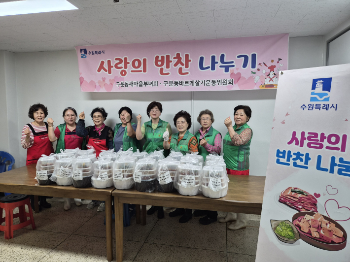 구운동 새마을 부녀회원들이 정성스레 만든 반찬과 함께 사진을 찍고 있다.
