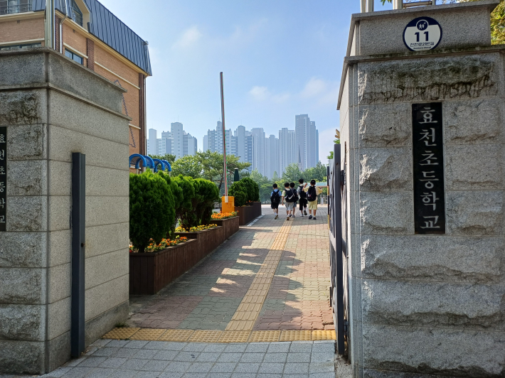 효천초등학교 정문 손바닥 정원의 꽃향기 속에 등교하는 학생들