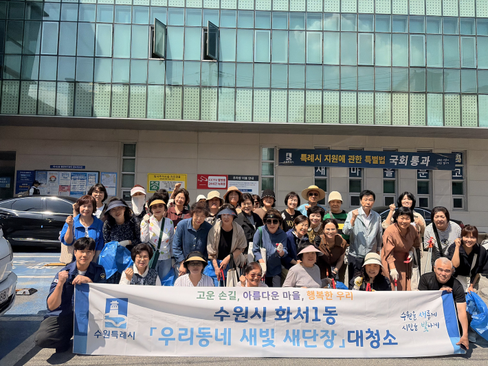 화서1동 청사 앞에서 대청소 시작 전 통장협의회 회원들과 함께 파이팅을 외치고 있다.
