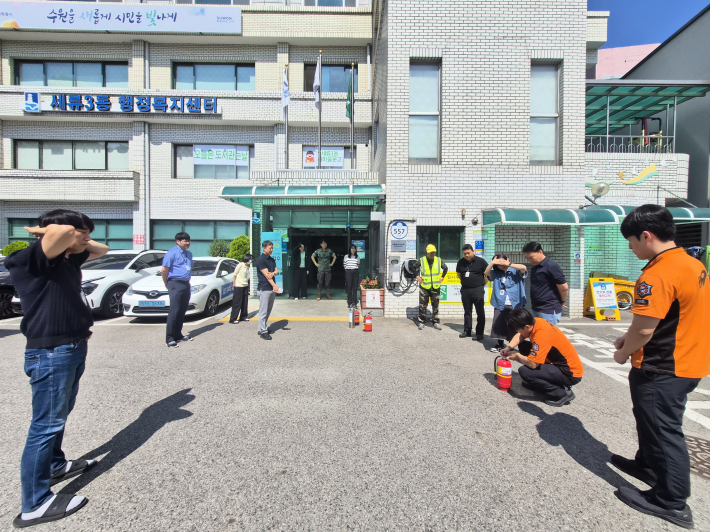지난 9일 세류3동 행정복지센터 청사 앞 주차장에서 열린 합동 소방훈련에서 직원들이 소화기 사용법 교육을 받고 있다.