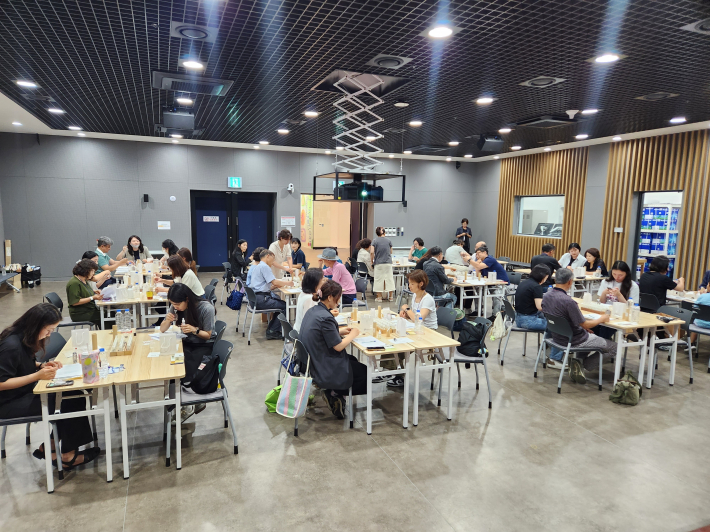 완성된 향수를 살펴보며 체험을 즐기는 참가자들.