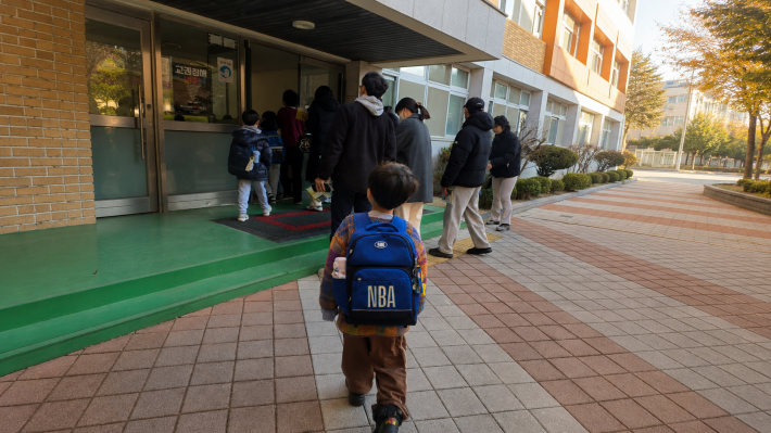 초등학교 입구로 들어가는 아이의 모습. 초등학교 입학 초기에는 낯선 등굣길에 적응하는 시간이 필요하다.