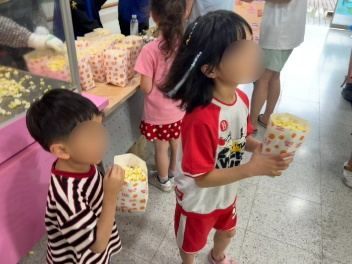 아이들이 팝콘을 받아 들고 환하게 웃고 있다. 환경 실천과 나눔이 함께한 축제였다.