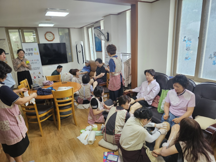 발사랑이웃사랑 봉사단이 경로당 어르신들께 발마사지를 하고 있다. 