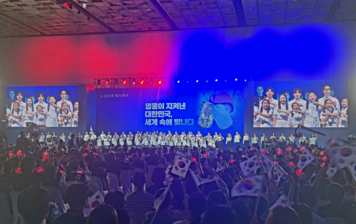 태극기와 응원봉을 흔들며 6.25의 노래를 부르고있는 