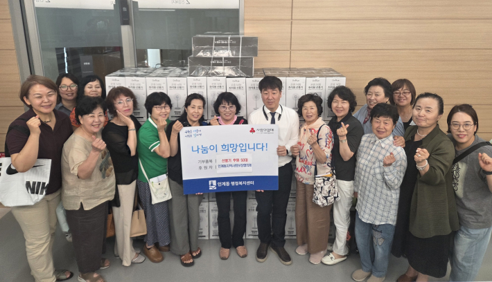 인계동 지역사회보장협의체 위원들이 선풍기 전달을 하며 기념촬영을 하고 있다.
