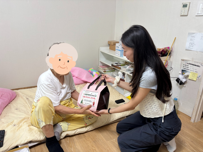 미래회계법인 직원과 함께 열무김치를 어르신들께 전달하는 사진