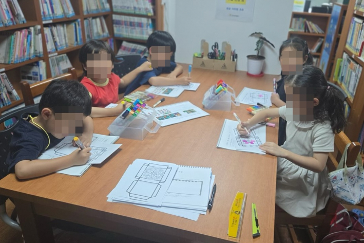 정2새마을문고 봉사자와 아이들이 정2새마을문고에서 창의미술 프로그램 활동을 진행하고 있다.
