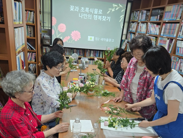 지역어르신들이 정2새마을문고에서  재활용 꽃꽂이로 「마음 나누기」 행사에 참여하고 있다.