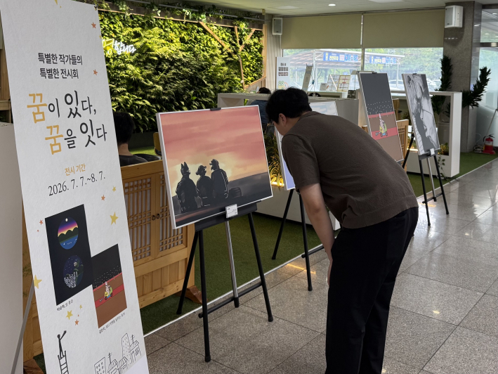 권선구청을 방문한 구민이 「특별한 작가들의 특별한 아트워크 展 꿈:다」를 관람하고 있다.