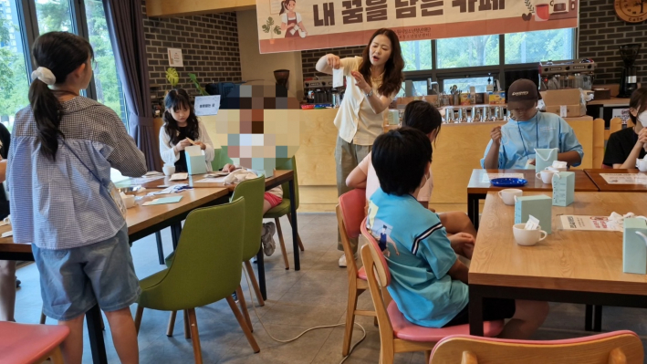 커피를 탈 때 포장 뜯는 방법을 말하고 있는 바리스타 선생님