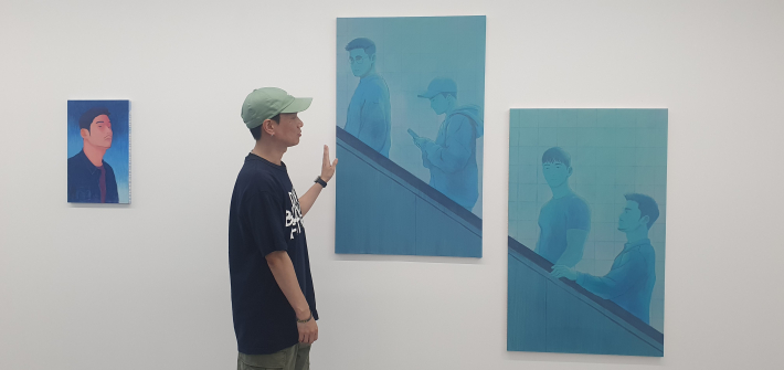 푸른색 에스컬레이터 연작 앞에서 작품의 구성과 제작 과정을 설명하는 최하민 작가.