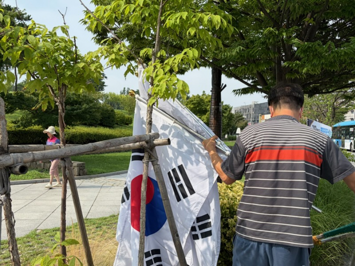 화서1동 새마을협의회 회원이 태극기를 게양하고 있다.