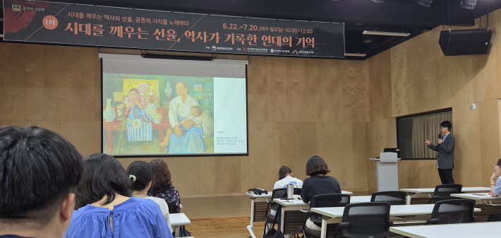 곽동기 작가가 임군홍의 가족을 소개하고 있다. 