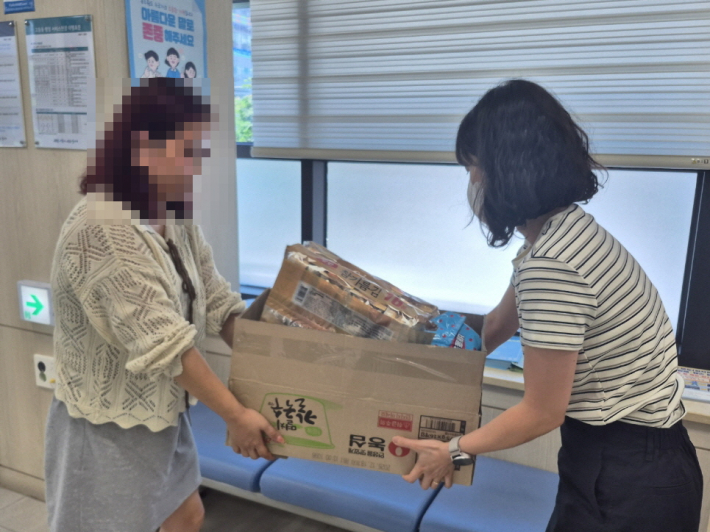 고등동 행정복지센터에서 사례대상자에게 식료품 꾸러미를 전달하고 있다. 