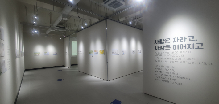 갤러리 아트랩 1층에서 개관전 《사람은 자라고, 사랑은 이어지고》가 열리고 있다. 그림책 속 삽화를 통해 성장과 가족, 삶의 여러 순간을 만날 수 있다.