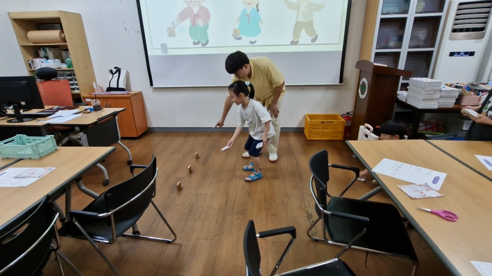 비석 치기를 조심스럽게 하고 있는 아이