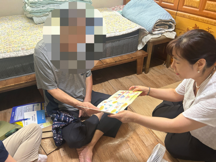 어르신에게 폭염 대비 예방수칙을 안내하고 있다.