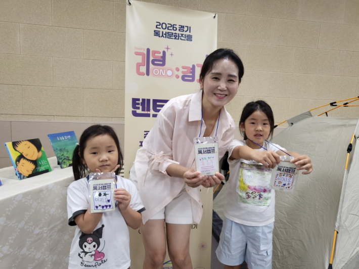 지온·지유네 가족이 직접 만든 네임텍을 들어 보이며 환하게 미소 짓고 있다.