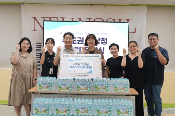 능실종합사회복지관과 수도권기상청 관계자들이 생수 1,000개 후원 전달식에서 기념촬영을 하고 있다.