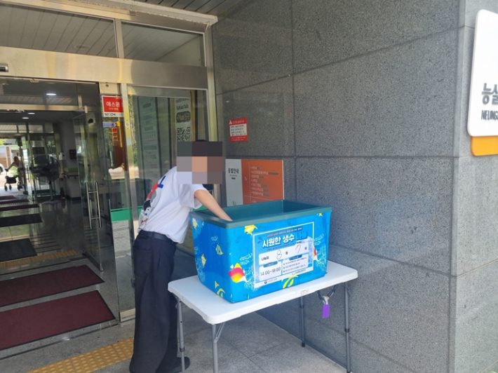 복지관을 방문한 지역주민이 폭염 대응을 위해 비치된 생수를 가져가고 있다.