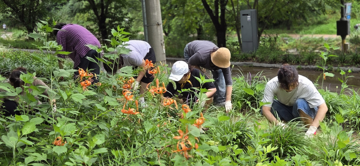 정원단들이 더운 날씨에도 서로 협동하며 정원을 관리하고있다