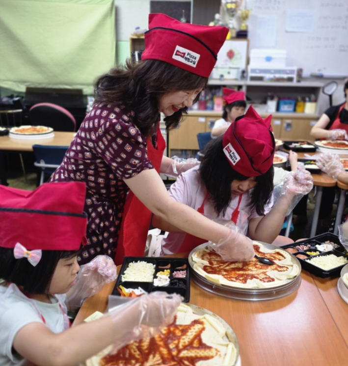 수원특례시 여성리더회 김미애총회장이 아이들과 함께 피자를 만들며 이야기를 나누고 있다.