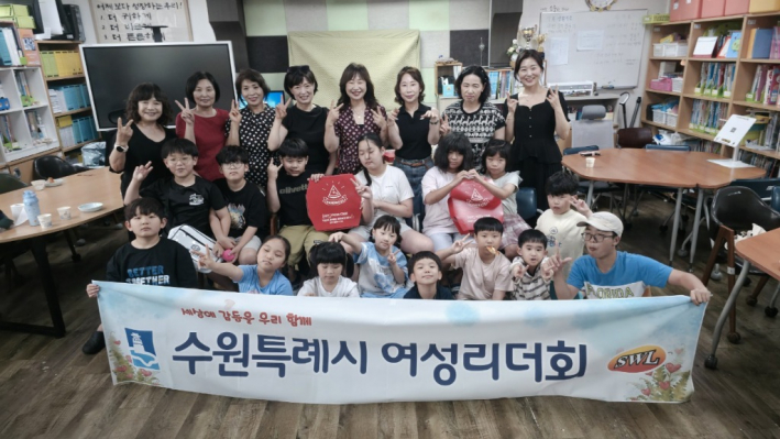 수원특례시 여성리더회 회원들과 길벗지역아동센터 아동들이 기념촬영을 하고 있다.