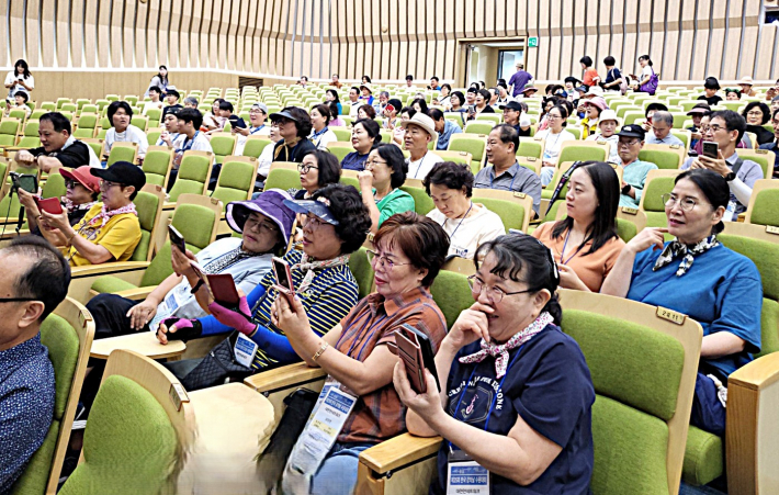참가자들이 휴대전화로 환경 OX 퀴즈에 참여하고 있다.