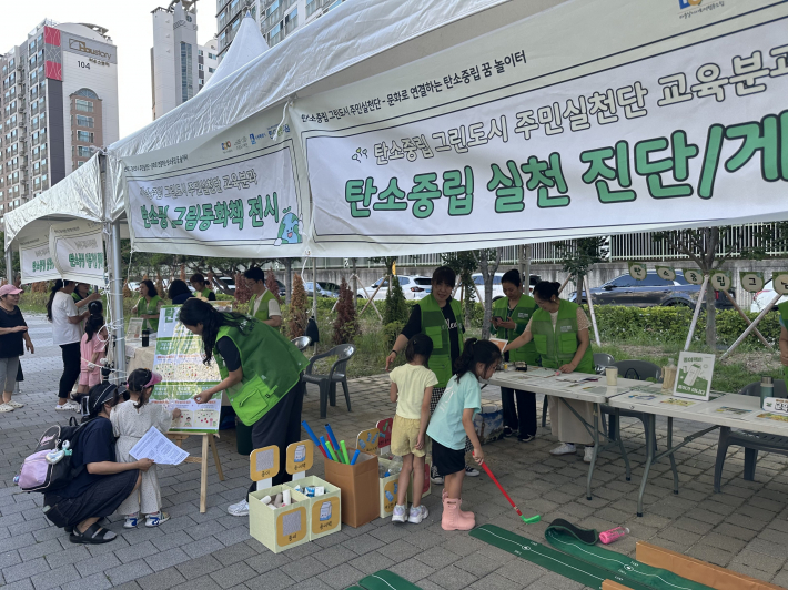 탄소중립 그린도시 주민실천단이 오목천역 상부에서 홍보 캠페인을 하고 있다.