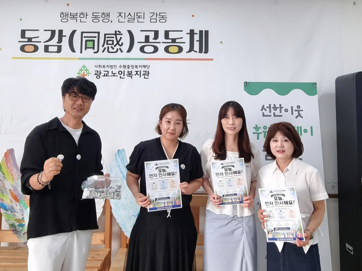 광교입주자대표협의회 정관하 회장(왼쪽)과 광교공동체 자율봉사자(오른쪽)가 복지관을 방문해 스마일 뱃지 110개를 전달했다.