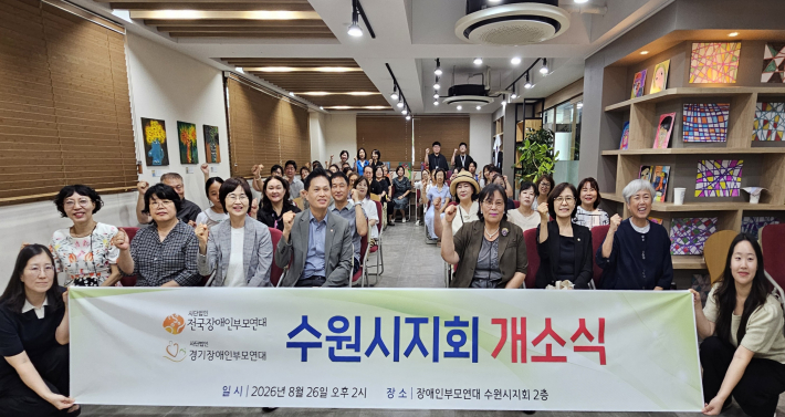 사)경기장애인부모연대 수원시지회 개소식에 참석한 내빈과 회원, 관계자들이 손을 들어 힘차게 파이팅을 외치며 기념촬영을 하고 있다.