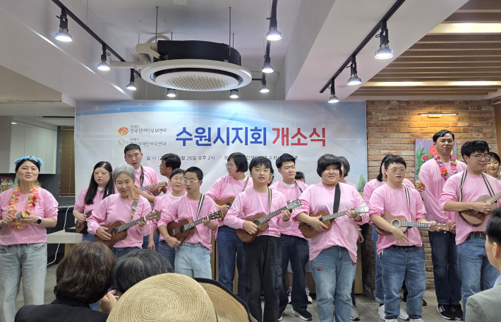 수원시지회 개소식 식전 행사에서 우쿨렐레 동아리 단원들이 분홍색 단체티를 맞춰 입고 경쾌한 축하공연을 펼치고 있다.