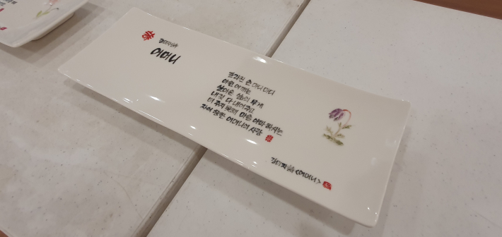 강미자 작가의 '어머니'. 도자기 접시에 시와 작은 꽃 그림을 함께 담았다.
