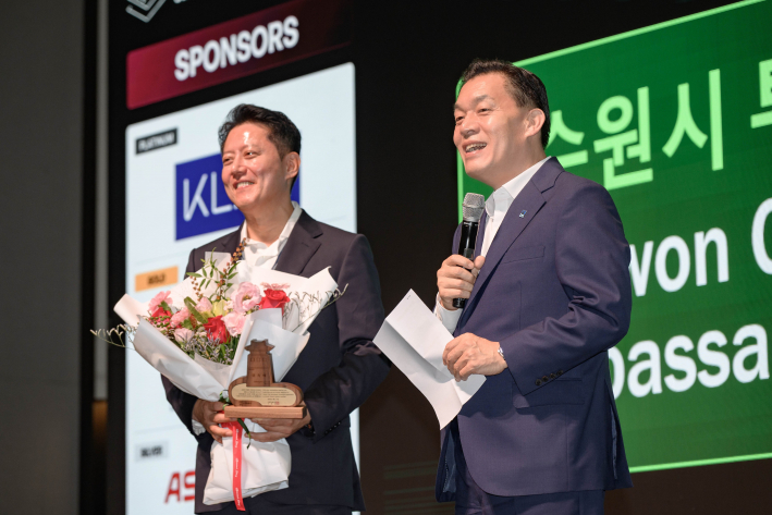 이재준 수원특례시장이 앤드류 김 ㈜레이저발테크놀러지 대표에게 위촉패와 꽃다발을 전달한 후 인사말을 건네고 있다.