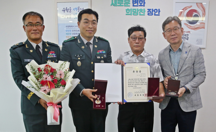 장안구청장과 3대대장이 유가족에게 무공훈장 전수를 하고 있다.