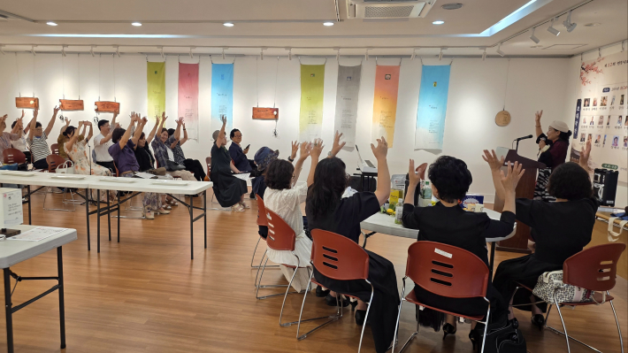 사회자가 손뼉과 발장단을 활용한 간단한 레크리에이션을 진행해 참석자들의 긴장을 풀어주고 있다.