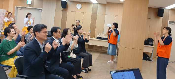 참석자들이 박수체조를 배우며 즐기고 있다.