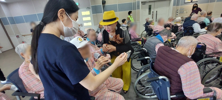 나소연 가수가 환우 관객의 독창을 손잡고 응원하고 있다.
