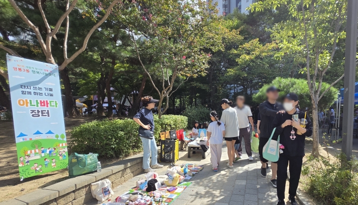 자원순환과 나눔을 실천하기 위해 마련된 '아나바다 장터' 부스에서 주민들이 다양한 중고물품을 둘러보고 있다.