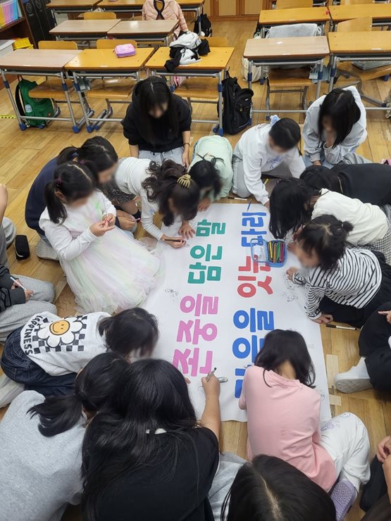 수원중촌초, 언어폭력예방교육주간 '공동현수막'제작 에 형제학년이 같이 참여하고 있다.