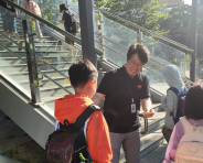 송상호 수원초등학교 교장이 육교 입구에서 등교하는 학생을 바라보며 미소 짓고 있다.